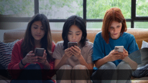 Tiga wanita muda duduk di sofa sambil fokus pada smartphone, mencerminkan perilaku pengguna yang jadi target strategi digital marketing efektif Jakarta.