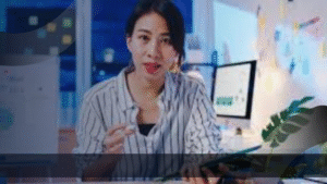 Seorang marketing specialist sedang menjelaskan strategi pemasaran di depan komputer dengan grafik digital di layar.