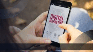 Seseorang sedang menggunakan smartphone yang menampilkan tulisan 'Digital Marketing', merepresentasikan akses cepat dan mudah terhadap marketing kit digital melalui perangkat mobile.