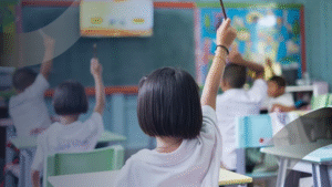 Suasana kelas aktif dengan anak-anak yang antusias mengangkat tangan, mencerminkan lingkungan belajar Ramah Anak bersama Konsultan pendidikan