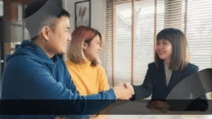 Seorang Product Marketing Specialist berjabat tangan dengan klien sambil tersenyum, menunjukkan keberhasilan membangun hubungan bisnis yang positif.