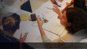 Diskusi tim akademik dalam proses kerangka teknis penyusunan kurikulum, menampilkan kegiatan kolaboratif dengan dokumen, catatan, dan materi pembelajaran di meja kerja.