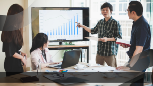 Seorang pria sedang mempresentasikan grafik "Quarterly Revenue"